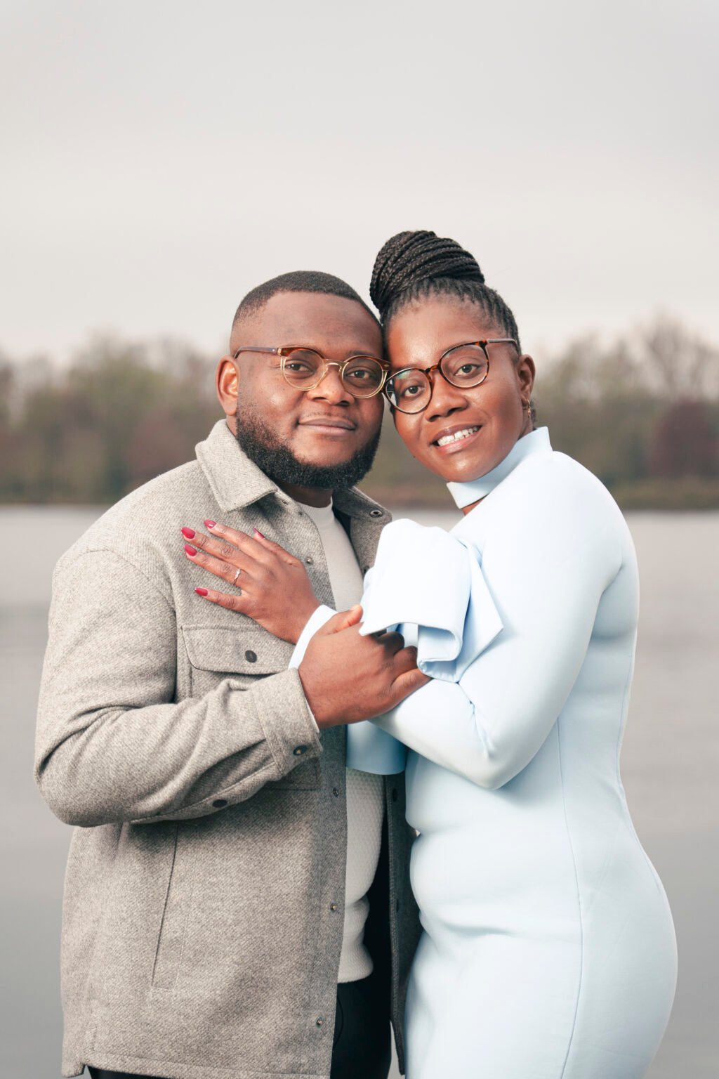 Couple de fiancés enlacés face à l'objectif au bord de l'eau, séance engagement à Bourges