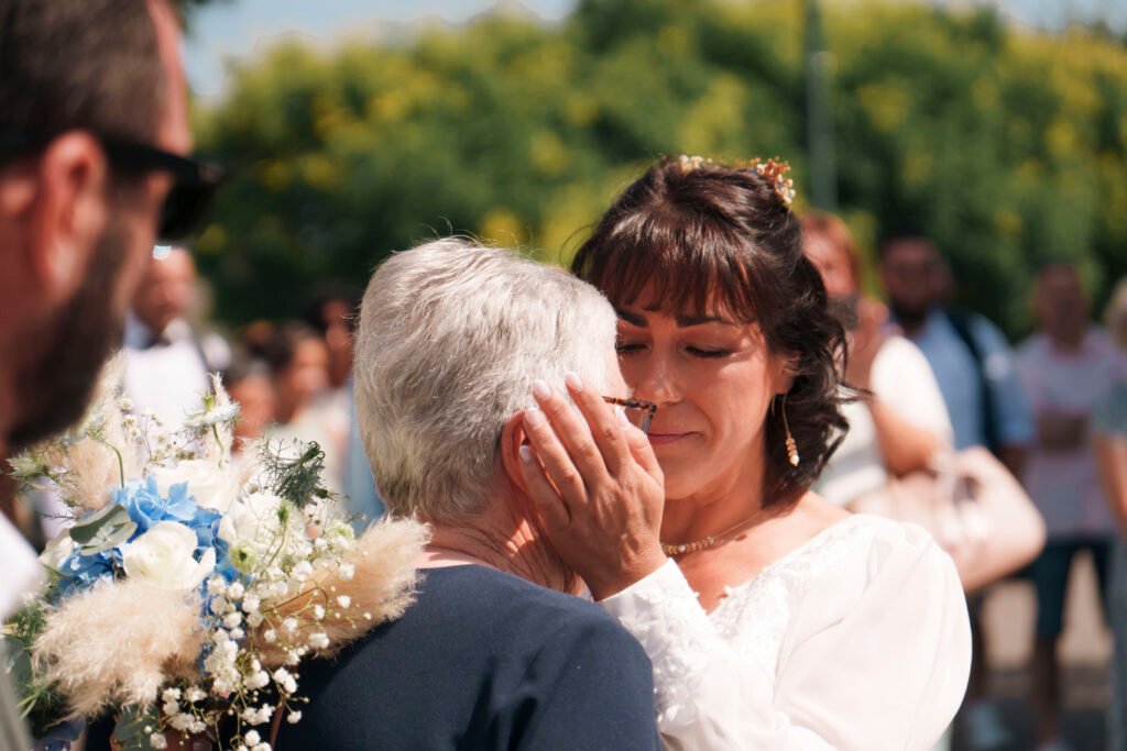 La mariée ému et prend le visage de sa mère à la sortie de mairie | Photographe de mariage à Bourges