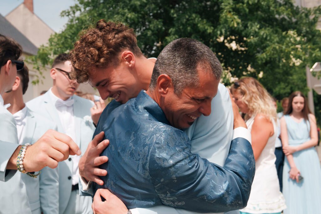 Le marié fait un câlin à son père à la sortie de la mairie de Quantilly | Photographe de mariage à Bourges