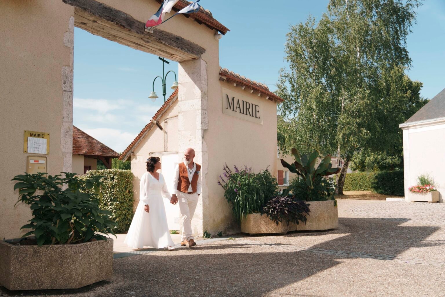 Un couple marié sortant de la mairie de Saint-Éloy-de-Gy | Photographe de mariage à Bourges
