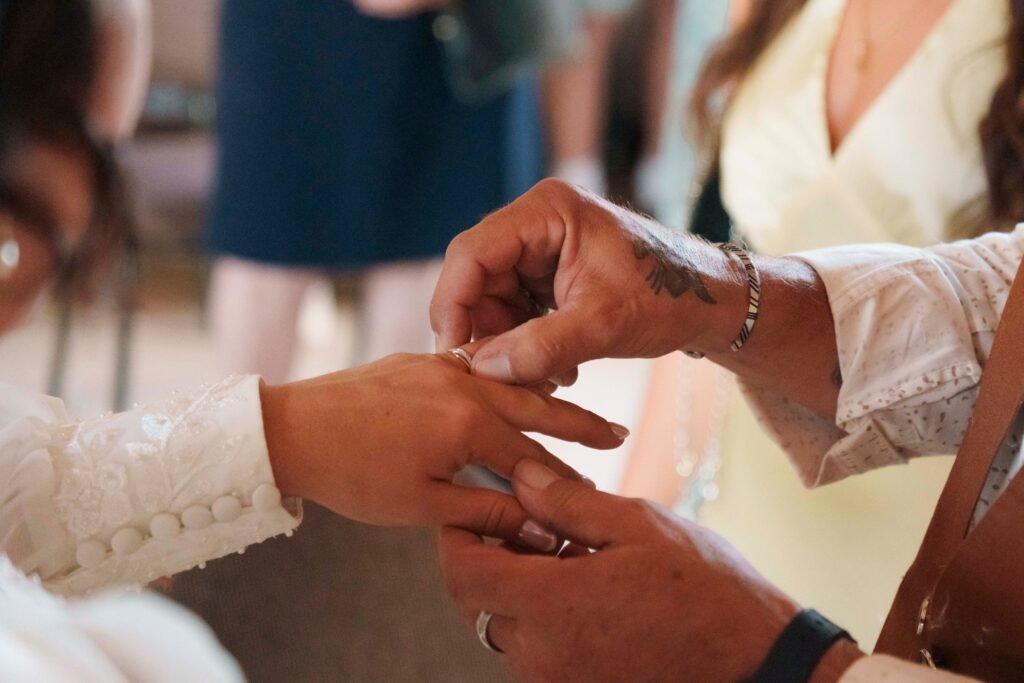 Gros plan sur les mains du marié qui glisse l'alliance au doigt de la mariée à la mairie de Saint-Éloy-de-Gy