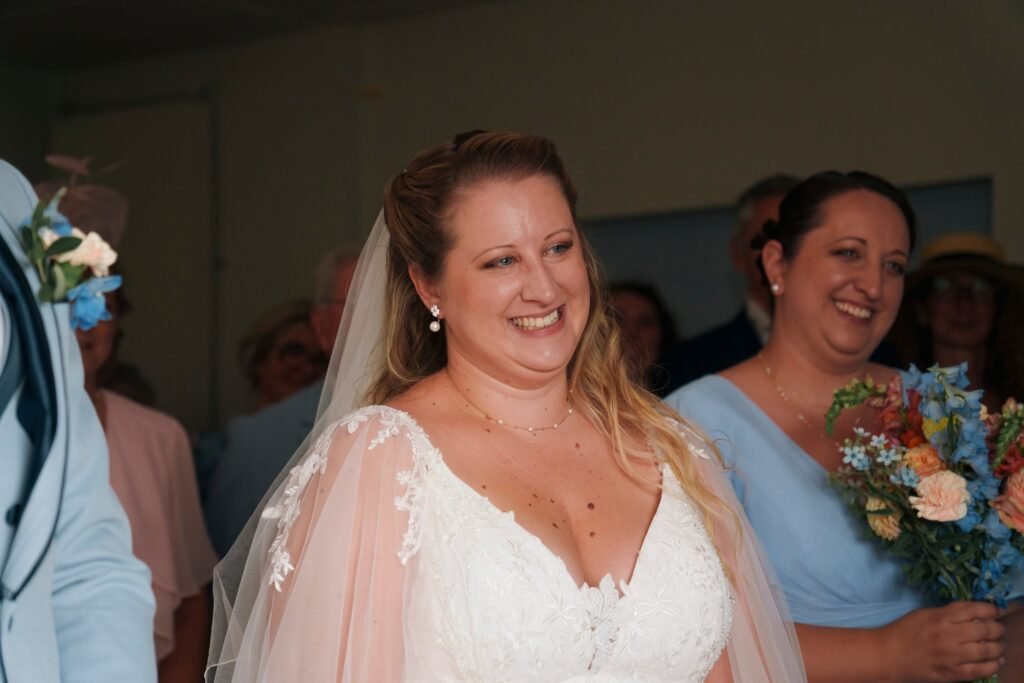 La mariée sourit à la mairie, une demoiselle d'honneur émue à ses côtés
