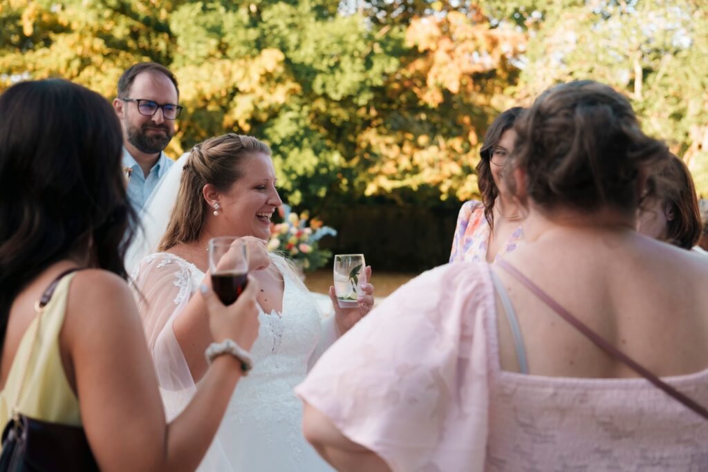 La mariée trinque et rit avec ses amies au vin d'honneur