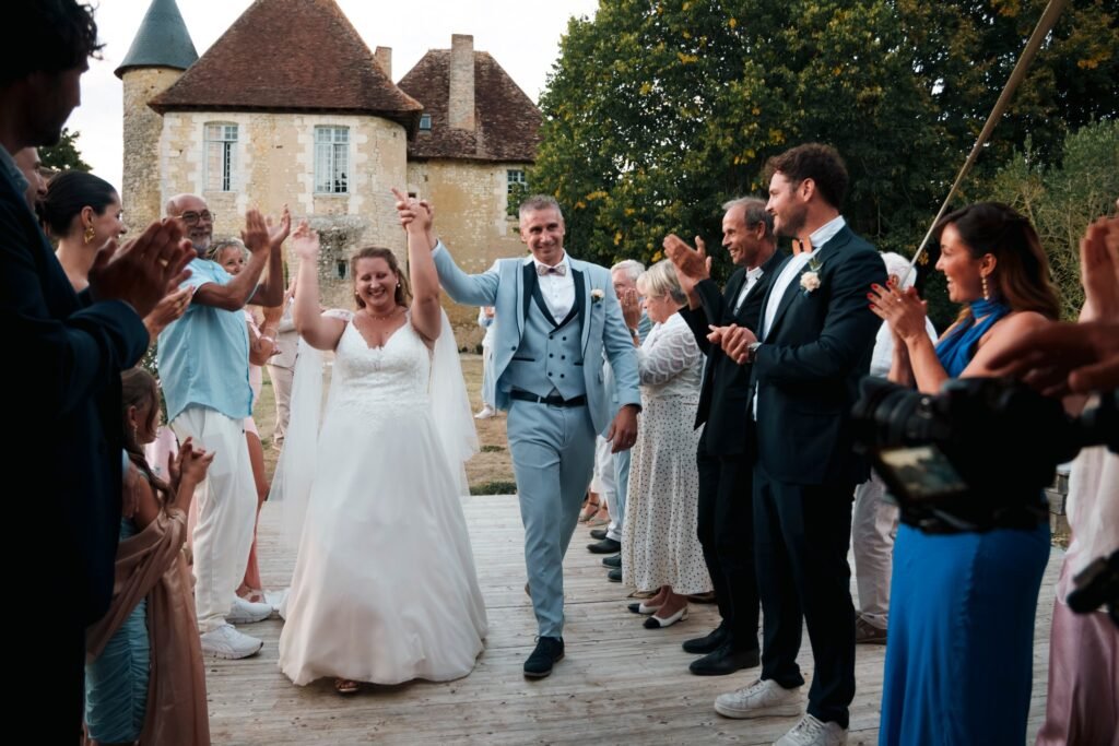 Les mariés entrent sous les applaudissements des invités devant le château