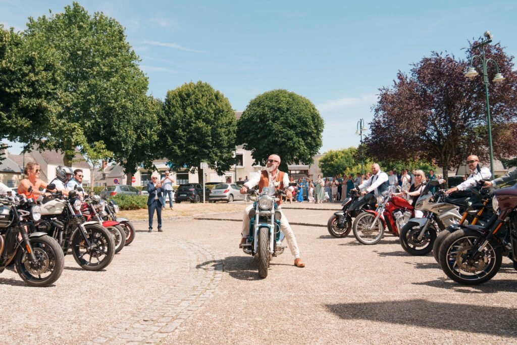 Le marié arrive à moto devant la mairie de Saint-Éloy-de-Gy, accueilli par une haie de motards et les invités