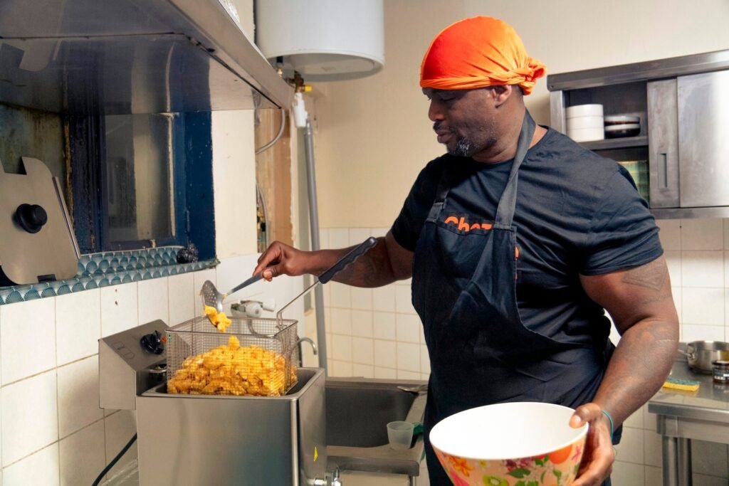 Le chef en bandana orange sort une friture pendant le service, reportage photo d'entreprise en cuisine