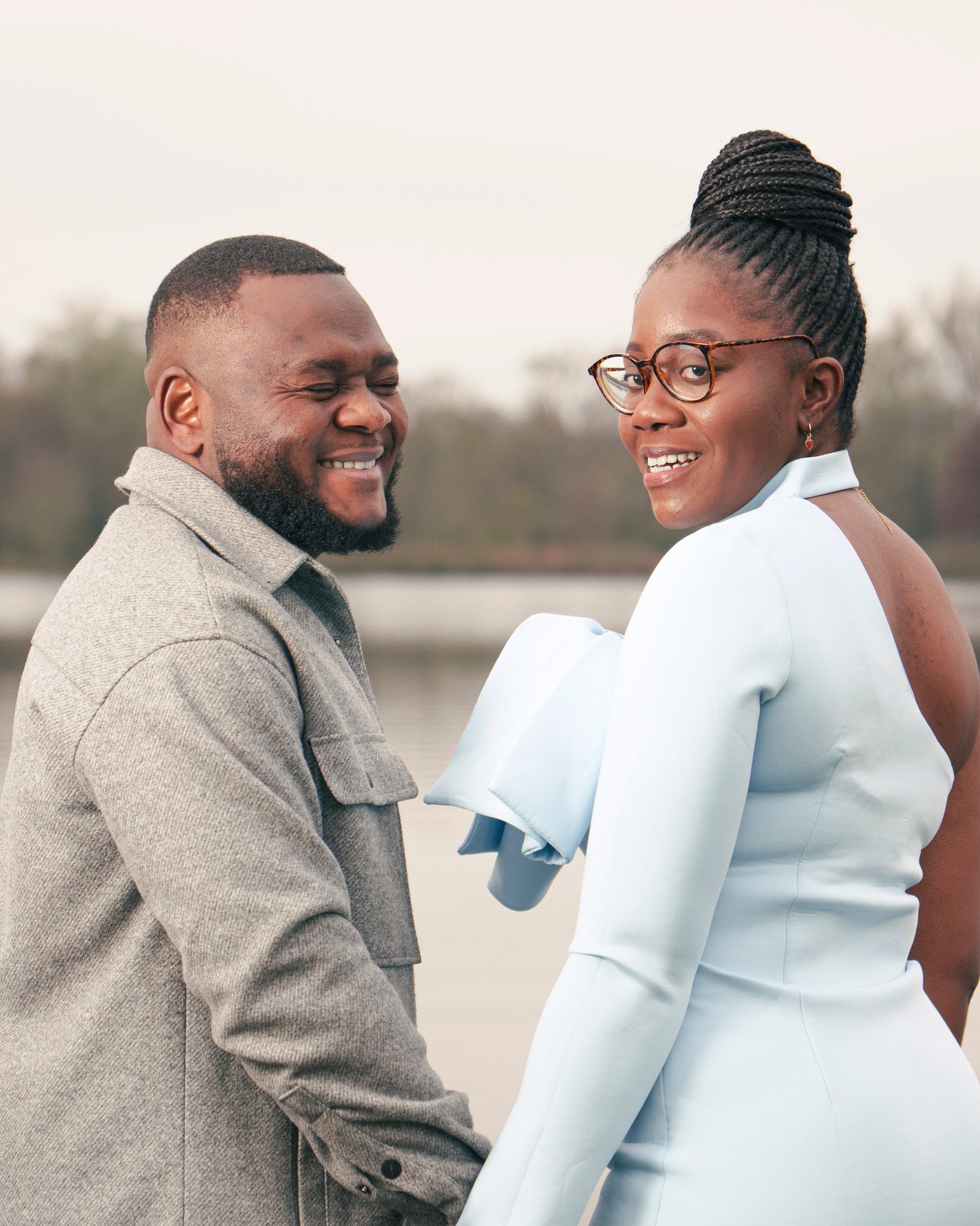 Des fiancés de dos se retournent en riant au bord de l'eau | Contacter votre photographe de mariage à Bourges
